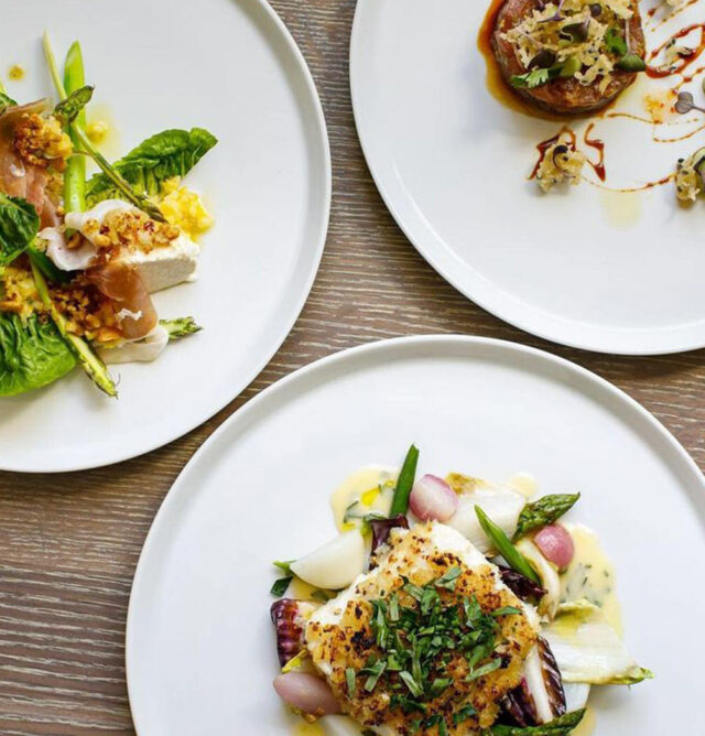 salads and entrees on a wooden table