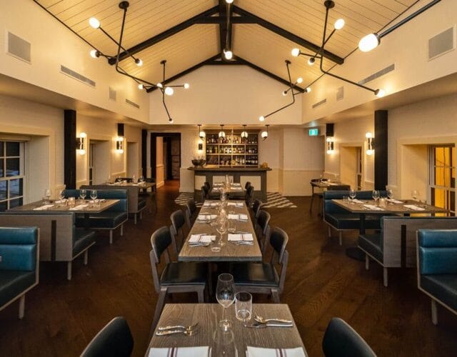 Spacious event room with tables and modern lighting